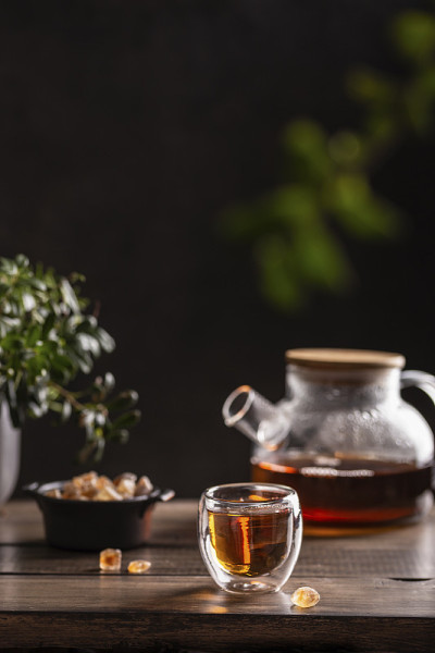 木桌上放着黑热茶和糖棒棒糖