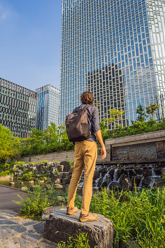 一名年轻男子在韩国首尔清溪川观光。清溪川是大规模城市重建事业的产物。韩国旅游概念