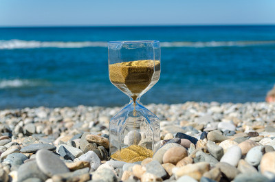 an hourglass stands on the beach against the backg