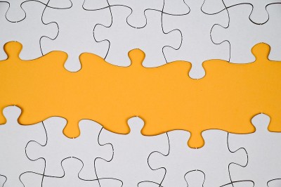 黄色背景上的白色拼图。副本的空间。