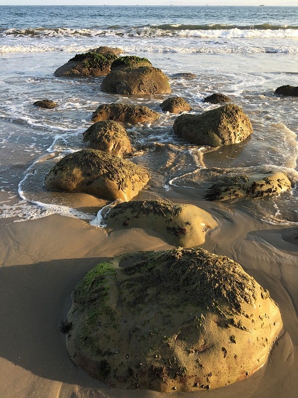 阳光和海浪拍打着岩石