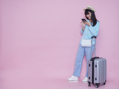 带着行李箱和智能手机的女人夏天旅行