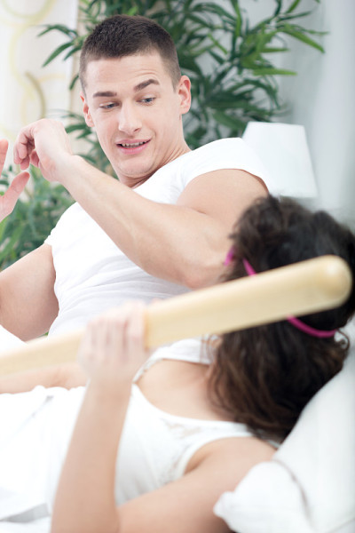 心烦意乱的女人用棒球棒攻击丈夫