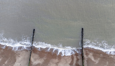 在英国萨福克郡，海浪拍打着沙砾海滩