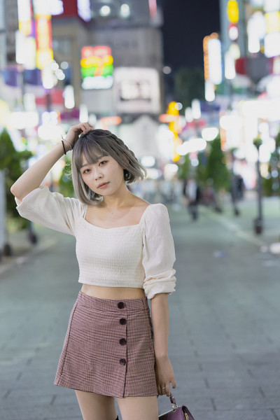 一名年轻女子晚上在东京摆造型