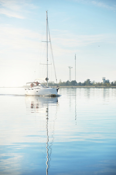 White sloop rigged modern yacht sailing after the 