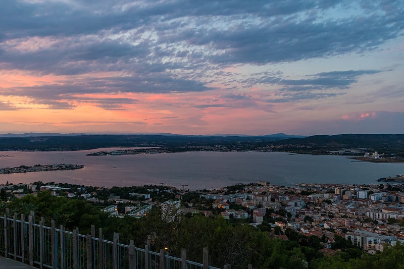 从Sète (Occitanie，法国)的圣克莱尔山顶看日落的Etang de Thau