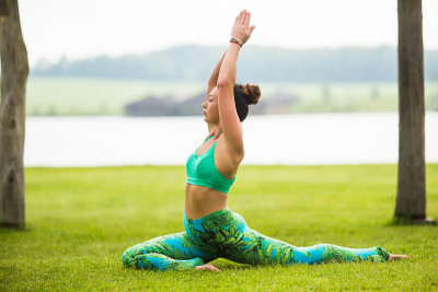 类篇rajakapotasana。瑜伽女孩训练户外自然背景。