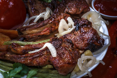 牛排羊肉搭配烤蔬菜，酱汁和洋葱。B-B-Q