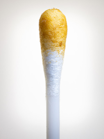 棉签与耳蜡隔离在白色背景。