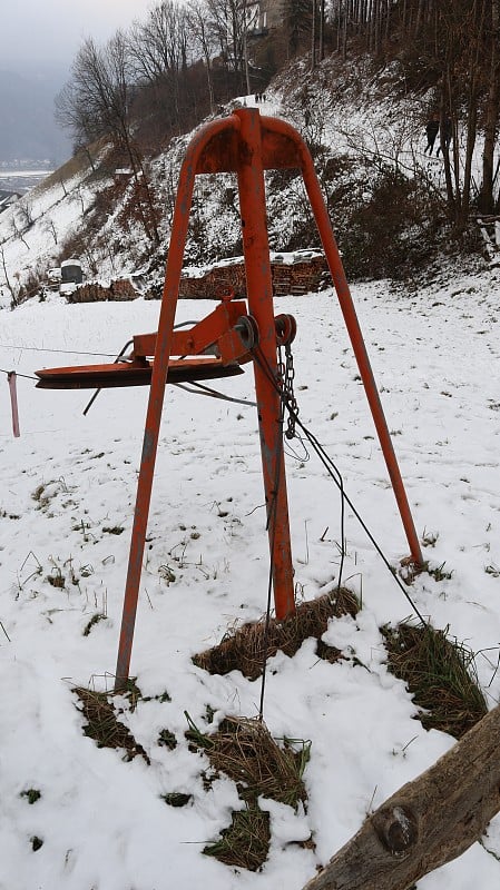 古董滑雪升降机熨烫升降机在红色大圆形滚柱钢丝绳和拉手拉在蒂罗尔