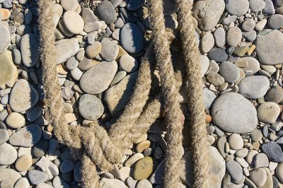 old marine rope on the pebble beach