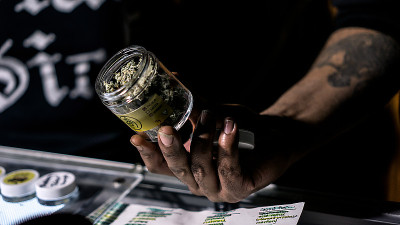 一个小贩炫耀着一罐大麻花