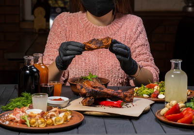 Young woman in shirt and black gloves begin eating