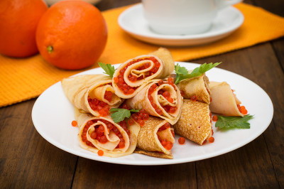 红鱼子酱煎饼卷。俄罗斯菜。平的。Maslenitsa。木制背景。特写镜头
