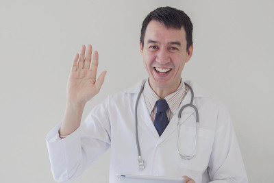 混合种族亚洲医学男性在线医生挥舞他的手和远程工作，远程健康，远程医疗，远程咨询的概念