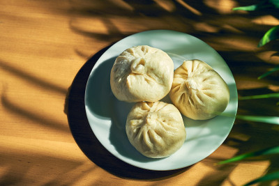 白盘子里有不同馅料(牛肉或猪肉)的包子。中国的食谱和菜肴。中国小笼包