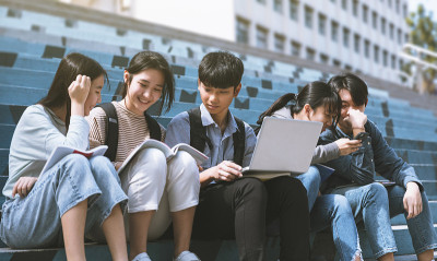 快乐的少年学生坐在楼梯上聊天