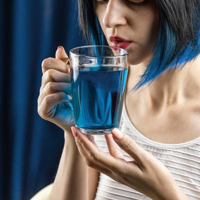年轻女子喝蓝色泰国茶