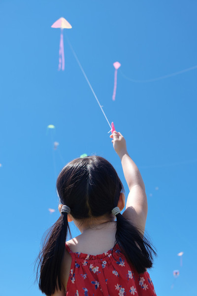 小女孩在阳光明媚的夏日里放风筝