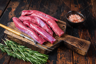 生羊里脊肉，羊肉里脊肉，木板配香草。深色木制背景。俯视图