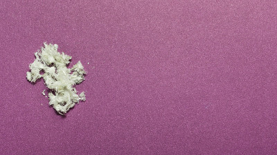 危险的矿物石棉特写在一个紫罗兰的背景