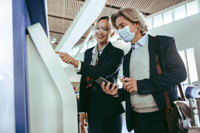 协助商务旅客自助办理登机手续的机场工作人员