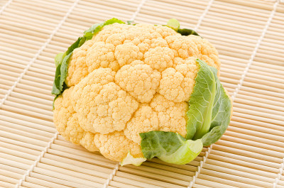 白色背景上的寿司竹席上的橙色花椰菜