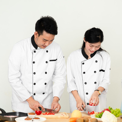 亚洲厨师教他的厨师助手准备食物，工作生活概念，运动模糊。