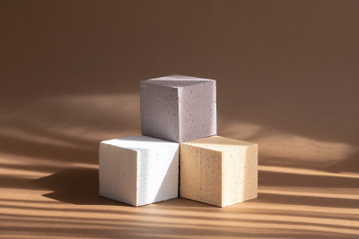 3d讲台，用于包装，化妆品的展示。三个不同颜色的立方体，米色，白色，棕色，在阳光下排列成基座的形状