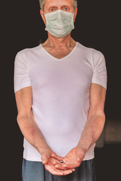 戴着防护口罩的男子，手臂有静脉炎