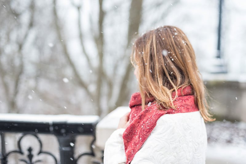 雪花落在站在户外的女人身上