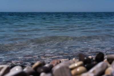 一个波浪滚过布满岩石的海岸。卵石滩。海滨。