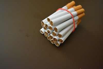 香烟包装上的红色橡皮筋固定在棕色哑光背景上。
