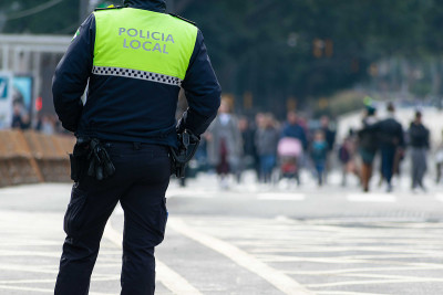 一名警察的特写镜头，制服上用西班牙语写着“当地警察”
