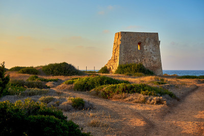 Torre Pozzelle遗迹，一个古老的海岸瞭望塔在一个彩色的日落奥斯图尼普利亚意大利