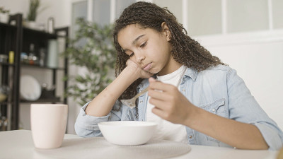 心烦意乱的美国黑人少女吃麦片，食欲不振，情绪波动