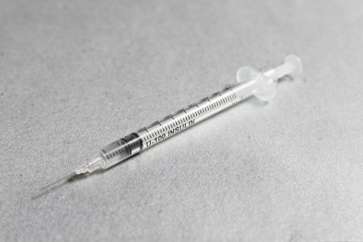 银色背景上刻着胰岛素的注射器。糖尿病的概念