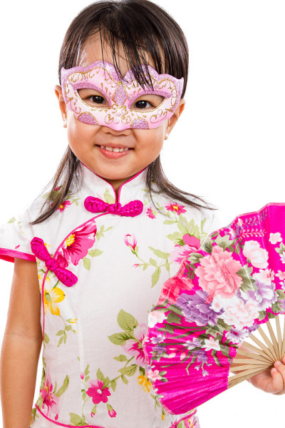 亚洲小中国女孩戴着面具，拿着东方扇子
