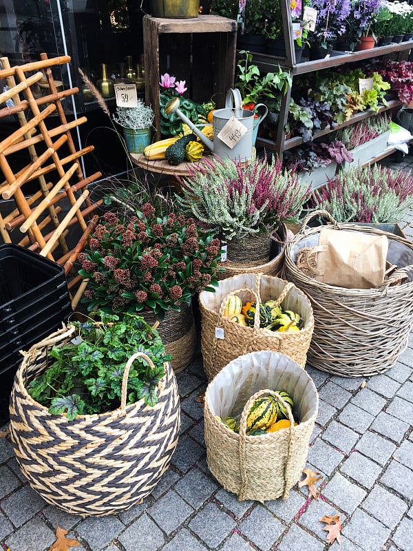 花店外挂满秋天植物和装饰品的篮子。