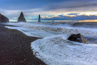 Reynisfjara的黑沙滩和冰岛南部海岸dyrholey海角的Reynisfjall山。