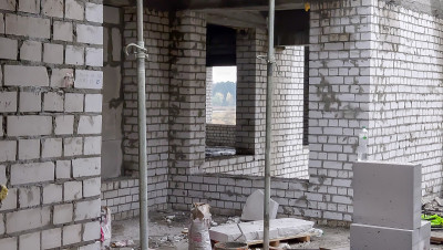 未完成的住宅建设。建筑工地背景上的白色砖块。从内部的建筑视图。楼宇的内部维修工作。