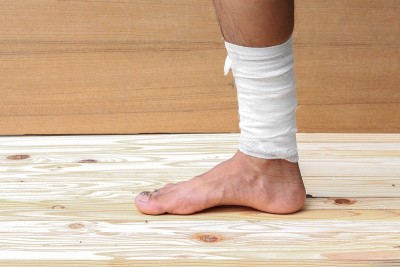 用纱布包扎足部溃疡患者男性正在包扎他的伤口
