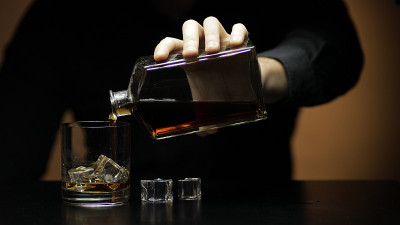 将威士忌、白兰地倒入玻璃杯中。酒保斟酒。轮廓