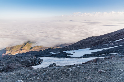 在活动的维拉里卡火山上的缆车顶部俯瞰风景，从上面看乌云密布的天空，有雪和岩石
