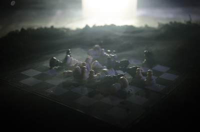 棋牌游戏的经营理念和竞争理念以及战略理念。象棋人物在烟雾缭绕的黑暗背景上。