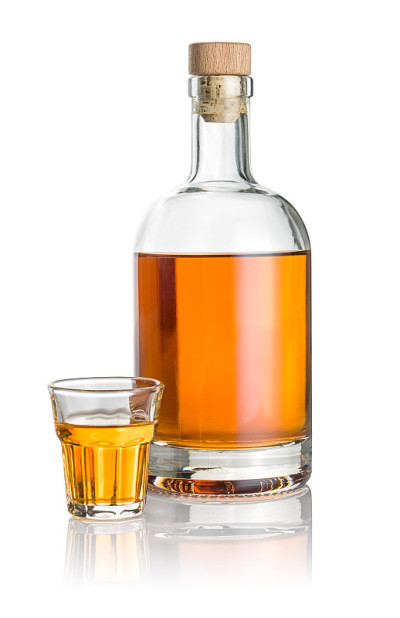 瓶子和斜面小酒杯装满琥珀色液体