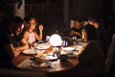美丽的一家人在露台边吃晚餐边谈笑