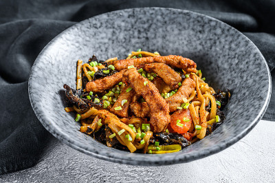 乌冬炒面，猪肉和蔬菜。白色背景。俯视图