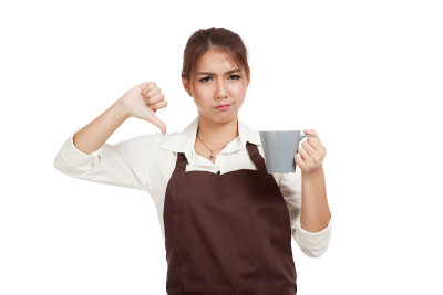 穿着围裙的亚洲女服务员对咖啡很反感